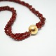 Per Borup; Clasp of 14k gold, with carnelian necklace.L. 43 cm. Clasp Dia. 15 mm.Stamped ...