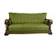 En sofa med 
stil fra 
renæssanceperioden, 
polstret i 
grønt stof og 
dekoreret med 
håndskårne ...