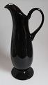 Pitcher from 
Holmegård, violet 
glass, 20th 
century. H: 34 
cm. Round foot, 
with handle.
