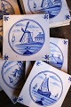 Decorative, old Dutch tiles with blue painted motifs of houses, church and mill. 
24 pieces...