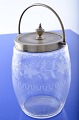 Biscuit bucket 
of clear glass 
with carvings 
of birds and 
vine leaves, 
with nickel 
mounting. ...