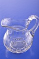 Creamer of 
clear glass. 
Cream jug, 
height 9.2 cm. 
Height at 
handle 9.5 cm. 
Condition : 
some  ...