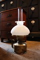 Old kerosene 
lamp in brass 
with white opal 
glass 
lampshade. 
The kerosene 
lamp is in an 
...