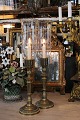 A pair of old 
hurricane 
candlesticks in 
brass with fine 
glasses with 
wavy edges and 
polished ...