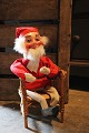 Old shop Santa 
in felt clothes 
and clogs 
sitting in an 
old wicker 
chair. Height: 
30cm.