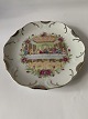Decorative 
plate with a 
religious motif 
of the Last 
Supper, 
surrounded by a 
floral motif. 
The ...