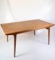 This teak 
dining table 
with extension, 
designed by 
Johannes 
Andersen and 
manufactured by 
Uldum ...