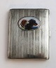 Alpaca 
cigarette case 
with dog motif. 
Length 8.5 cm. 
Width 6.5 cm. 
Signs of wear.