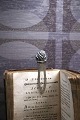 Old bookmark in 
silver 
(Stamped) with 
flower at the 
top.