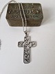 Silver necklace 
with large 
silver cross. 
The cross is 
decorated with 
flowers and 
designed by ...