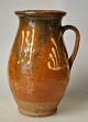 Antique Danish 
clay jug, 19th 
century. Red 
clay with brown 
and white 
glazes. H.: 19 
cm.