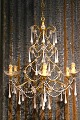 French chandelier in gilded metal and wood, decorated with white glass drops and 
chains...