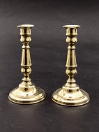 A pair of brass candlesticks on a round base