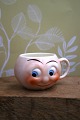Old children's cup in faience with funny face. H: 5.5cm. Dia.: 7.5cm.