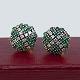 A pair of large 
round earrings 
in 14 kt. gold. 
adorned with 
diamonds and 
emeralds, set 
in white ...