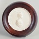 Meissen Biscuit plaque, c. 1970s.Circular relief plaque in white biscuit porcelain with a ...
