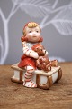 Royal Copenhagen Pixie in porcelain, no.764. Girl on a sled with a small teddy bear. Height: ...