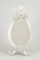 Venetian table mirror, Murano.Oval mirror with an ornate clear-glass frame, decorated with ...