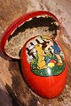 Old Easter egg in painted cardboard from the early 1900s with a motif of a little boy and girl ...