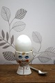 Old egg cup from the 1930s in porcelain with a painted funny face. Height: 6cm.