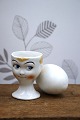 Old egg cup from the 1930s in porcelain with a painted funny face. Height: 6cm.