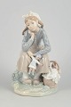 Lladró figurine, seated girl with doll.Fine porcelain figurine depicting a contemplative girl ...