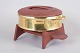 Jens H. Quistgaard for Dansk Designs, brass casserole with exotic wood lid and stand.Circular ...