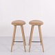 Pair of bar stools by Mater made in oak with seats upholstered in natural leather. Mater is a ...