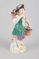 Meissen, grape boy figurine.Porcelain figurine depicting a boy carrying baskets filled with ...