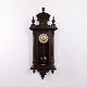 Antique wall / hanging clock by Junghans, crafted in oak from the 1920s. The clock has a classic ...