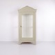 Antique display cabinet with grey painted surface, curved top and decorative carvings. The ...