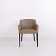 Armchair upholstered in beige-toned faux leather with a dark wooden frame. The chair has a ...