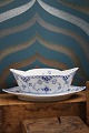 Boat-shaped sauce bowl on a solid saucer in Blue Fluted Half Lace from Royal Copenhagen...