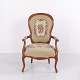 Antique wooden armchair in the French Louis XV style, probably dating from circa 1890–1920. The ...