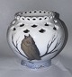 STANDING ON SIX LEGS: Round porcelain vase featuring openwork decoration and a full lace border. ...