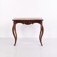 Antique mahogany fold-over table from the 19th century with a decoratively carved apron, elegant ...