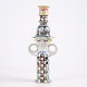 Figural candlestick in glazed ceramic depicting a stylised female figure with large circular ...