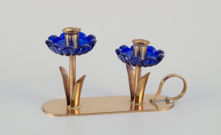 Gunnar Ander for Ystad Metall, Sweden. Candlestick holder in brass and blue art 
glass shaped like flowers. For two candles.