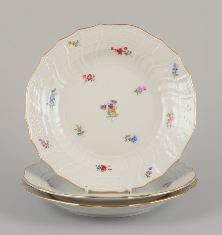 Meissen, Germany. Three porcelain luncheon plates.
Hand-painted with polychrome floral motifs.