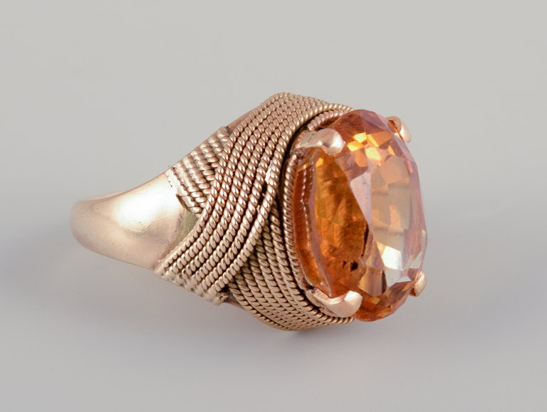 Swedish goldsmith. Large 18 karat cocktail ring adorned with faceted 
amber-colored citrin.