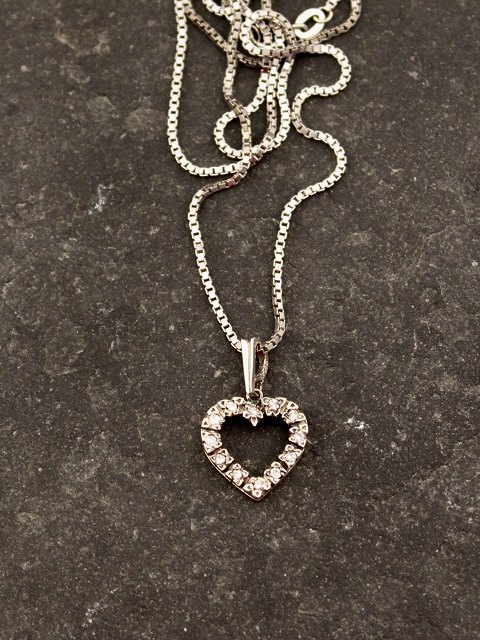 14 carat white gold heart pendant with several diamonds