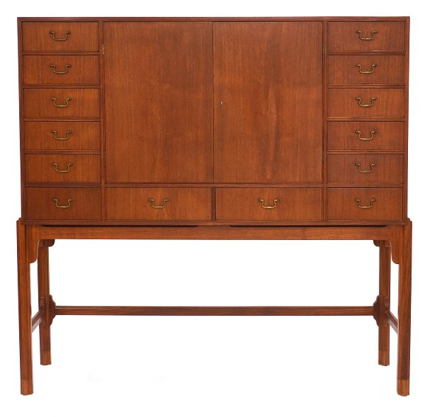 Chest of drawers designed by Knud Juul Hansen, crafted in teak. The piece features a total of 14 drawers and two doors at the front, concealing additional storage space. H: 160 cm.W: 160cm. D: 50cm